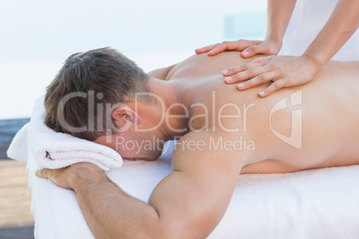 Handsome man getting a massage poolside