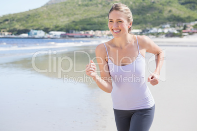 Pretty blonde jogging on the beach