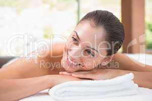 Beautiful smiling brunette lying on massage table with salt scru