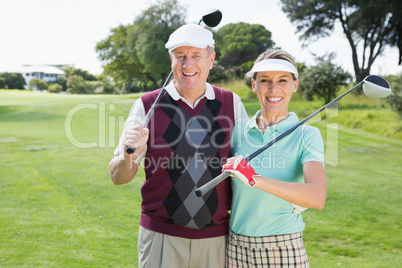 Golfing couple smiling at camera