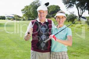 Golfing couple smiling at camera