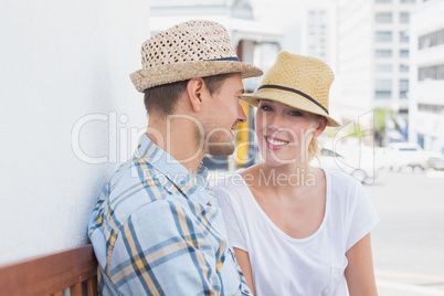 Young hip couple sitting on bench