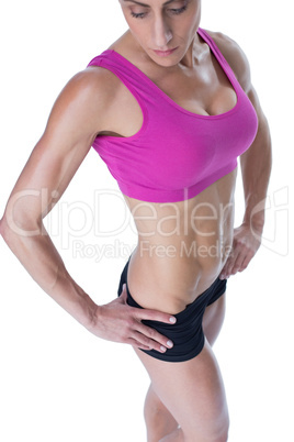 Female bodybuilder posing in pink sports bra and shorts