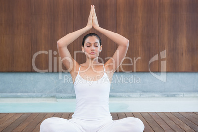 Peaceful woman in white sitting in lotus pose