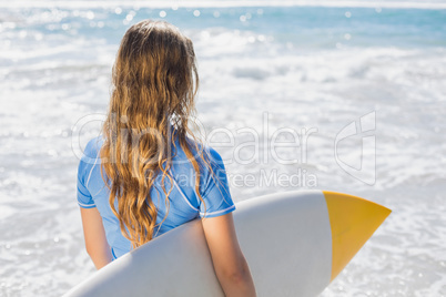 Fit surfer girl on the beach with her surfboard