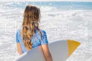 Fit surfer girl on the beach with her surfboard