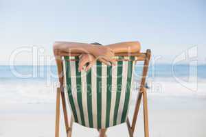 Woman relaxing in deck chair on the beach