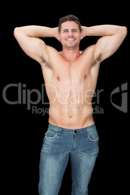 Happy muscular man posing in blue jeans