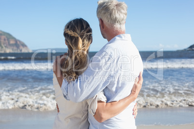 Couple on the beach looking out to sea