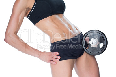 Female bodybuilder holding large black dumbbell mid section