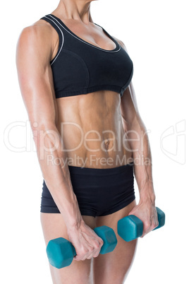 Female bodybuilder holding two dumbbells with arms down