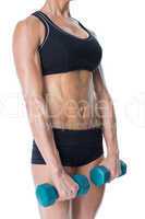 Female bodybuilder holding two dumbbells with arms down
