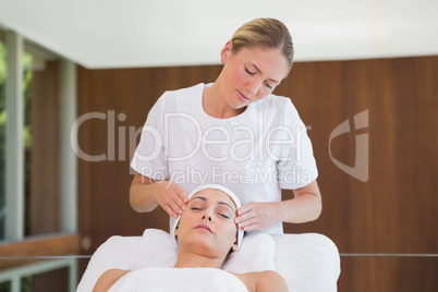 Peaceful brunette getting facial massage from beauty therapist Peaceful brunette getting facial massage from beauty therapist