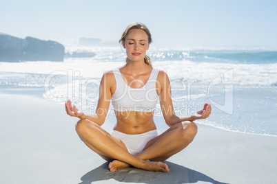 Gorgeous blonde in lotus pose by the sea