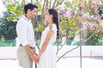 Attractive couple standing in garden holding hands