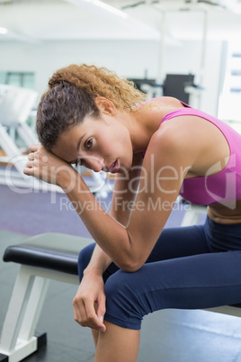 Tired fit woman taking a break on the bench