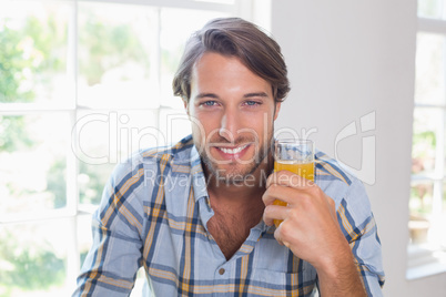 Casual smiling man having orange juice