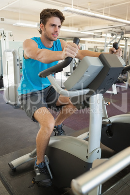 Smiling fit man on the exercise bike