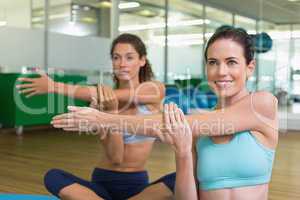 Fit women stretching on exercise mats