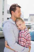 Hip young couple hugging woman smiling at camera