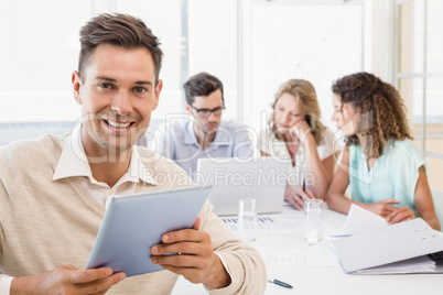 Casual businessman smiling at camera during meeting