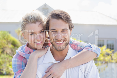 Cute couple smiling at camera together in their garden