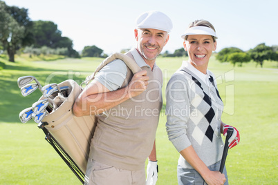 Golfing couple smiling at camera on the putting green