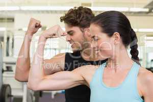 Fit attractive couple comparing biceps