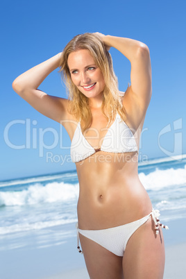 Beautiful blonde in white bikini on the beach