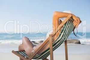 Woman relaxing in deck chair on the beach