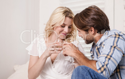 Young couple sitting on floor drinking wine