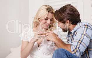 Young couple sitting on floor drinking wine