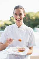 Smiling beauty therapist looking at camera holding plate with ho