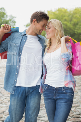 Hip young couple holding shopping bags