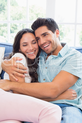 Attractive couple cuddling on the couch