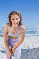 Sporty happy blonde standing on the beach