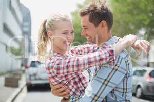 Couple in check shirts and denim hugging each other