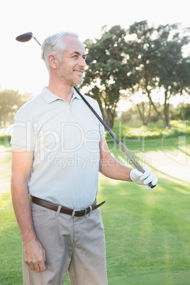 Smiling handsome golfer looking away