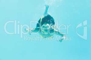 Brunette swimming underwater wearing snorkel