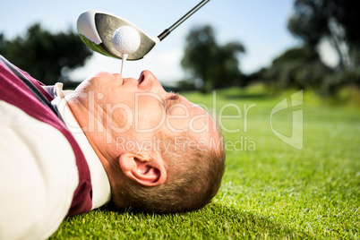 Golfer holding tee in his teeth