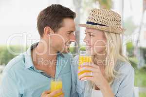Hip young couple drinking orange juice together