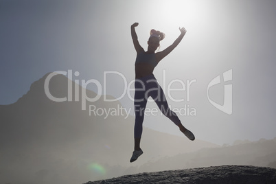 Sporty blonde on the beach on a rock jumping