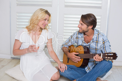 Handsome man serenading his girlfriend with guitar