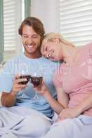 Happy couple sitting on couch with red wine