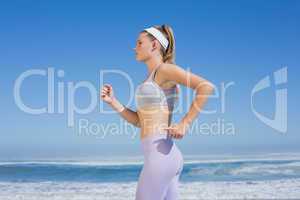 Sporty focused blonde jogging on the beach