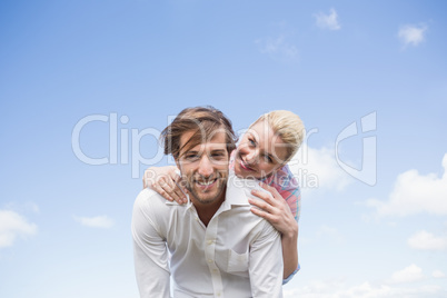 Handsome man giving piggy back to his girlfriend