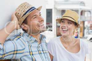 Young hip couple sitting on bench