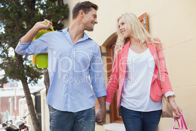 Stylish young couple standing with shopping bags