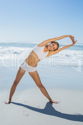 Gorgeous blonde standing and stretching by the sea