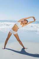 Gorgeous blonde standing and stretching by the sea